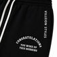 Close-up of black sweatpants with white drawstrings, white vertical text reading 'VILLEION STYLES' on the side, and white arched text reading 'CONGRATULATIONS YOU WOKE UP THIS MORNING' on the front.