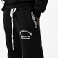 Black sweatpants with white drawstrings and white printed text on the left leg reading 'CONGRATULATIONS YOU WOKE UP THIS MORNING' and 'JULEION STYLES' printed vertically on the right leg.