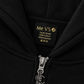 Close-up of a black zip-up hoodie showing the inner neck label with 'Me VS' and 'Youth Small 30% Cotton 70%Polyester' in gold text, plus a silver zipper with a matching metal pull.