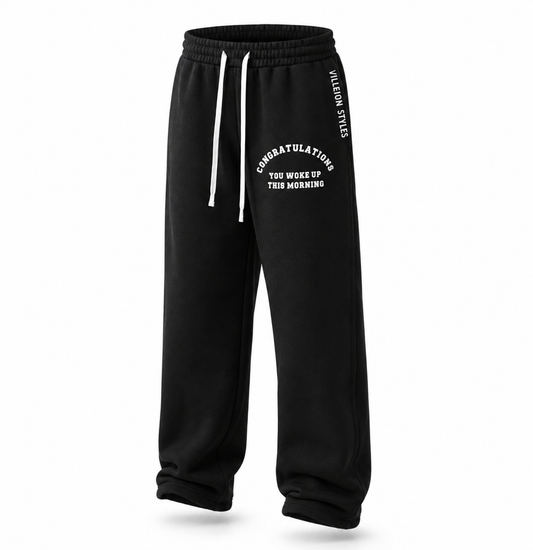 Black sweatpants with white drawstrings and white printed text on the left leg and side, shown on a clean white background.